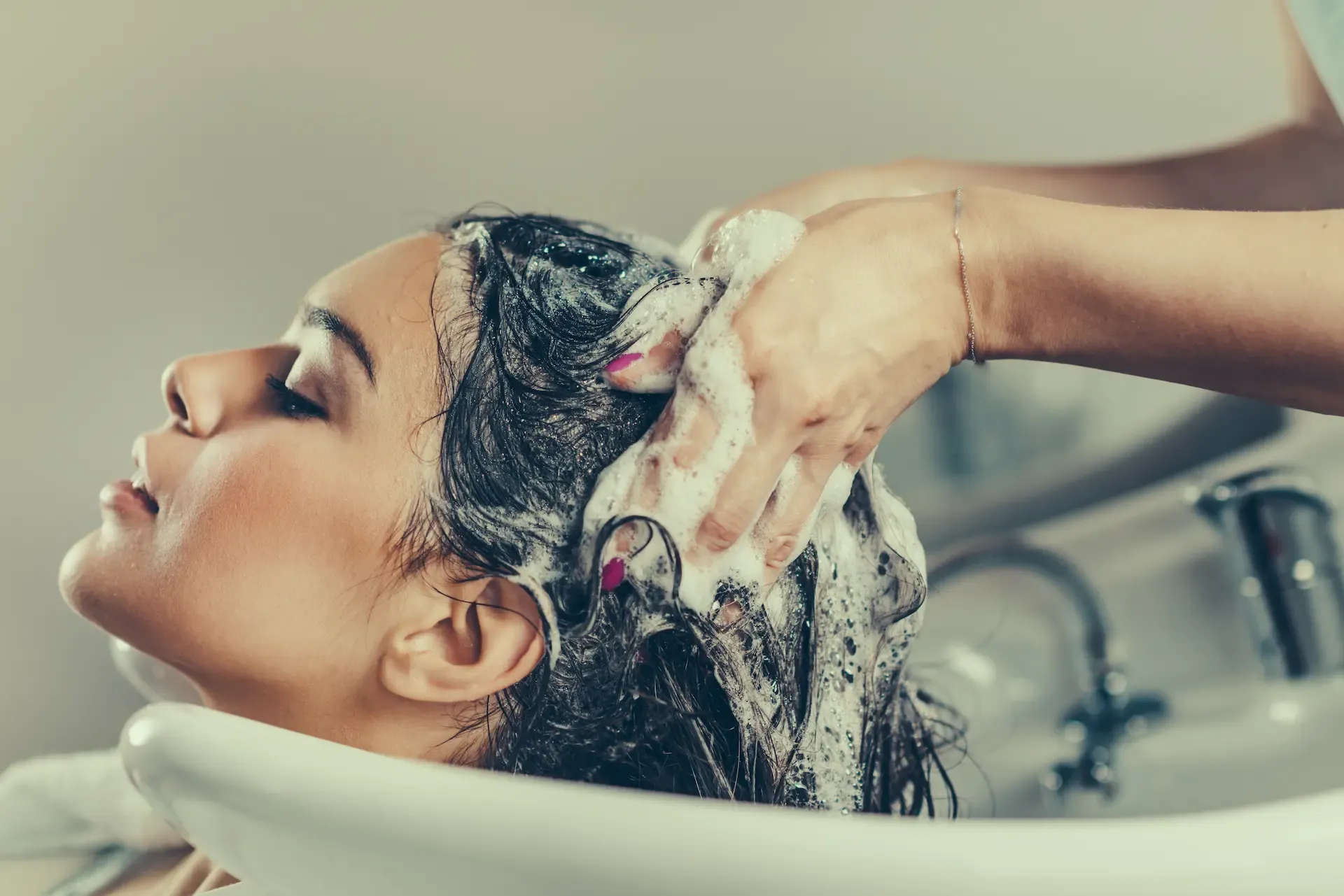 A salon guest receiving a hair and scalp treatment