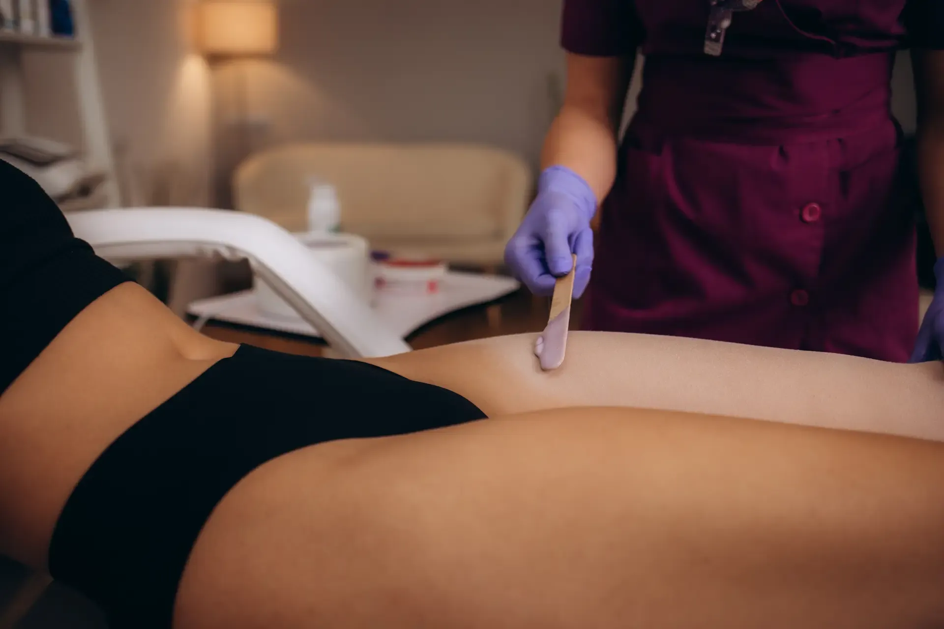 A photo of a woman having hair removed from her leg